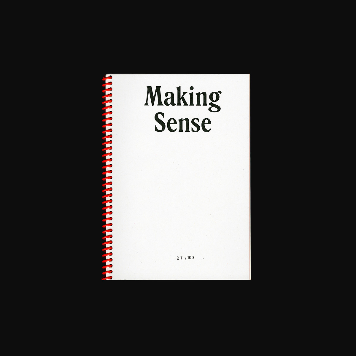 A scan of the front cover of the Making Sense catalogue. The publication is A5 sized, with a white cover and black text with the name of the exhibition in a dated, inky looking serif font. The catalogue is bound with bright orange spiral binding.